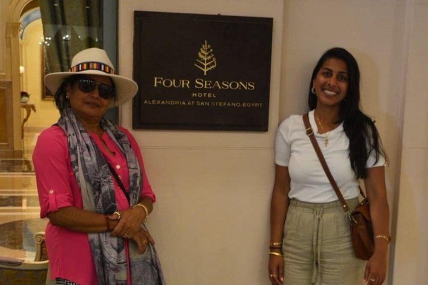 Dos personas de pie frente a un cartel del Hotel Four Seasons en Alejandría, Egipto. 3