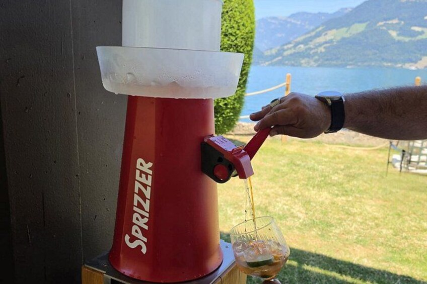A red beverage dispenser with a glass being filled. 2