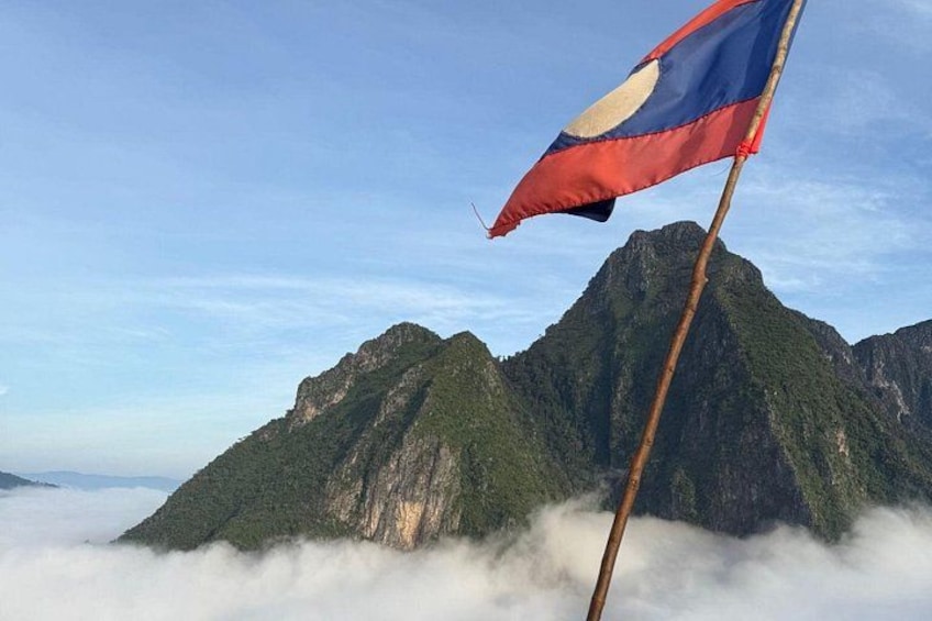 Een vlag op een paal, met een bergachtig landschap op de achtergrond. 2