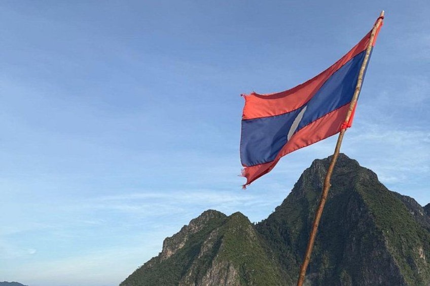 Een vlag op een mast met een bergachtig landschap op de achtergrond. 3
