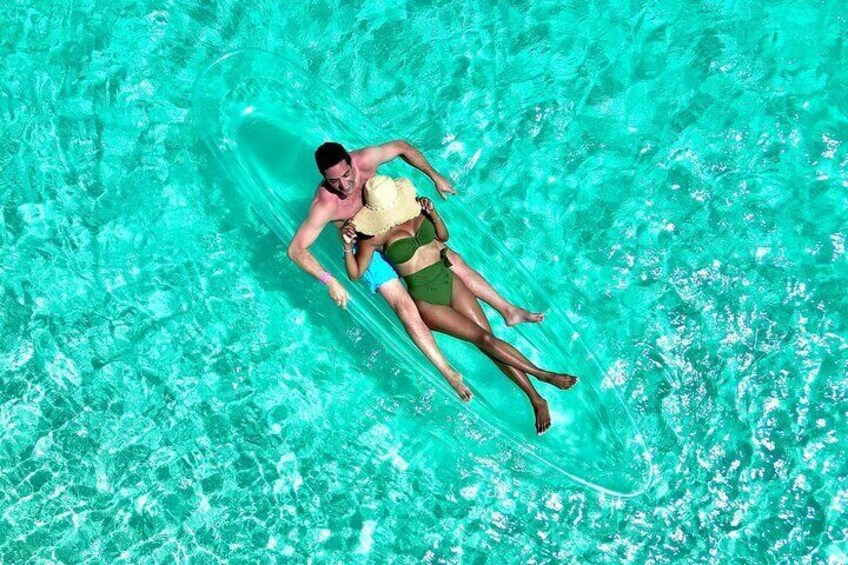 A person floating on a surfboard in a turquoise pool. 5