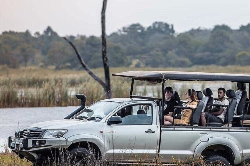 Een zilveren SUV met dakdragers geparkeerd bij een waterpartij. 4