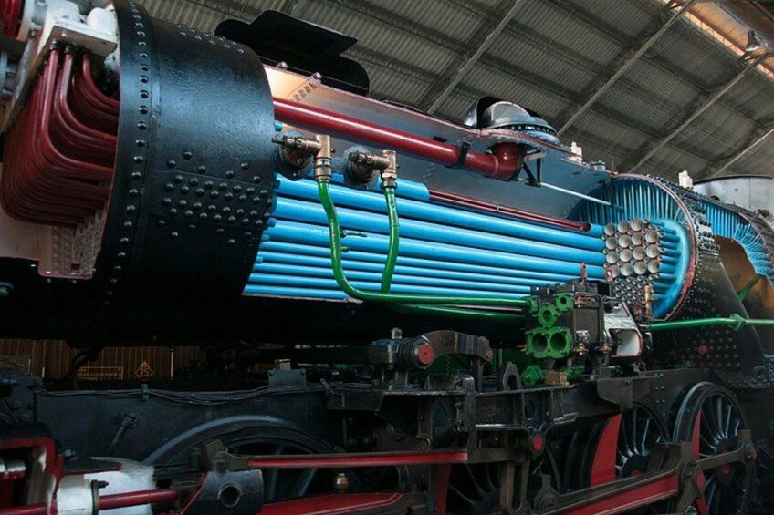 A steam locomotive with a large boiler, multiple pipes, and wheels. 2