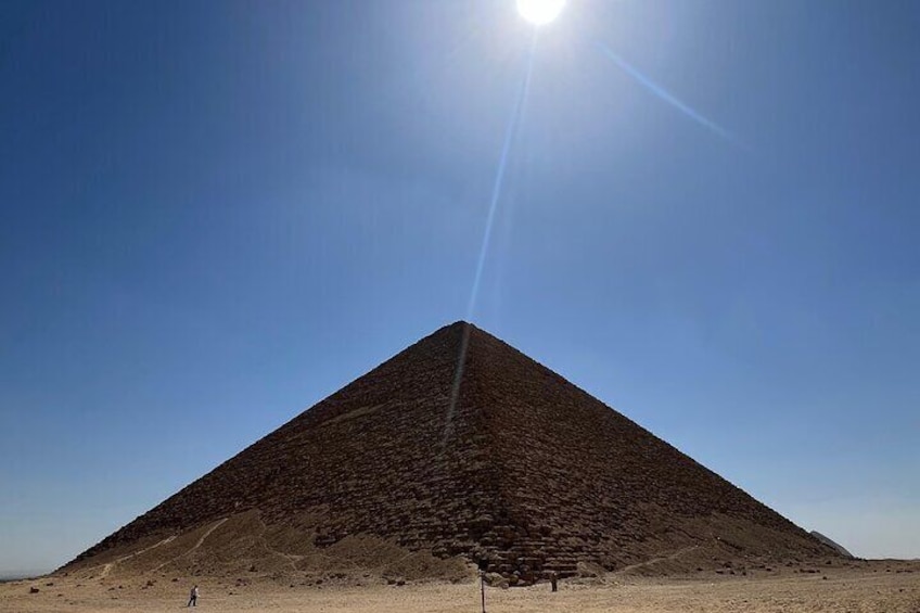 Una gran pirámide con cielo despejado y sol al fondo. 3