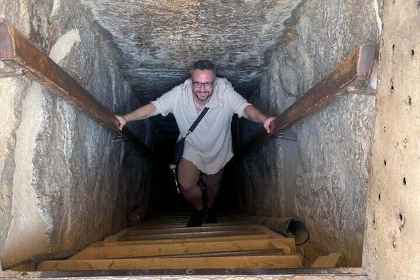 Una persona baja por una escalera de madera en un túnel de piedra. 4