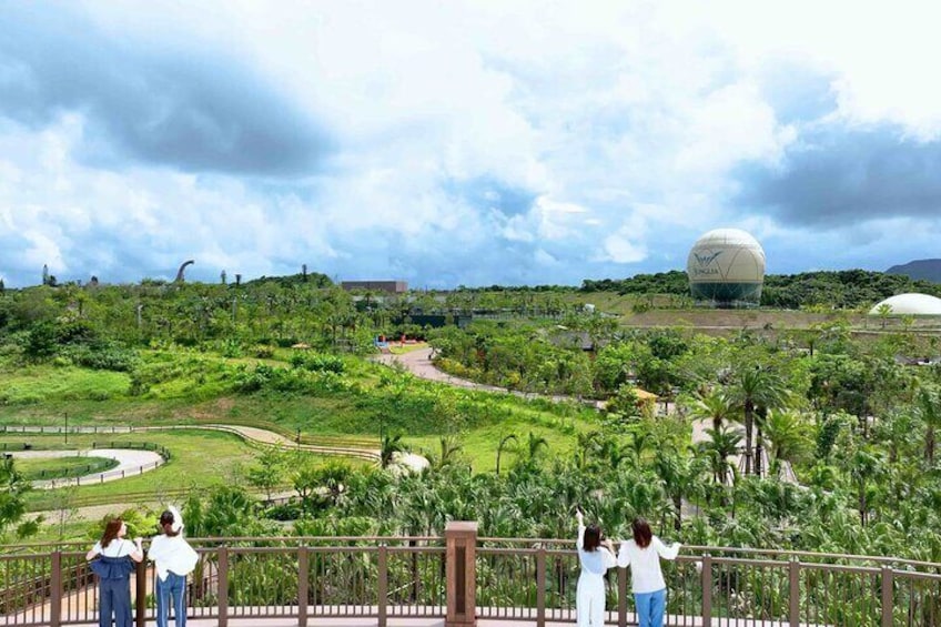 A lush green landscape with a large white dome structure in the distance. 5