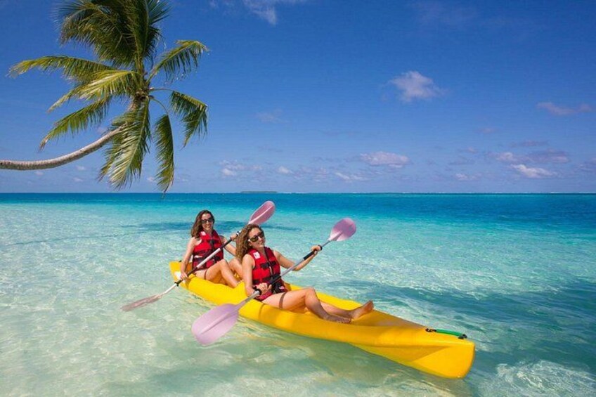 Two people kayaking on a yellow kayak in clear turquoise water with a palm tree in the background. 2
