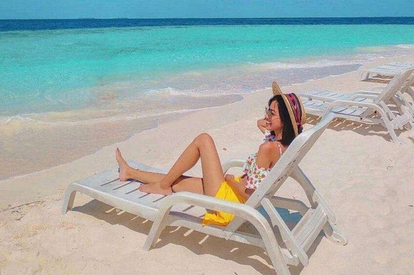 A person relaxing on a beach chair with a clear view of the ocean and sandy beach. 3
