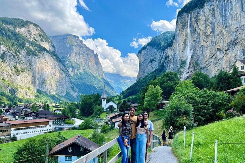 Un paysage montagneux avec une cascade, une église et un village. 3