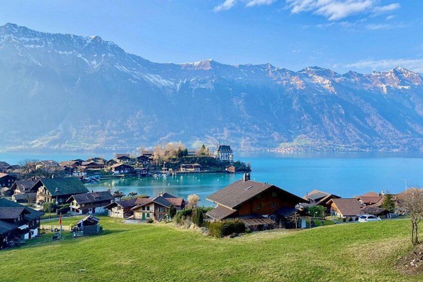 Un village au bord d’un lac, avec des maisons, un quai et des montagnes en arrière-plan. 4