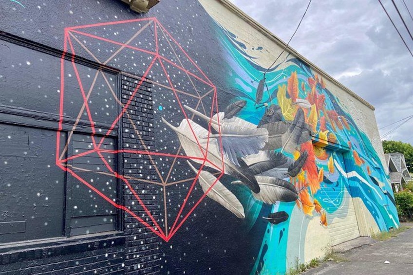 Un mural con formas geométricas y un colorido diseño de pez en un edificio. 4