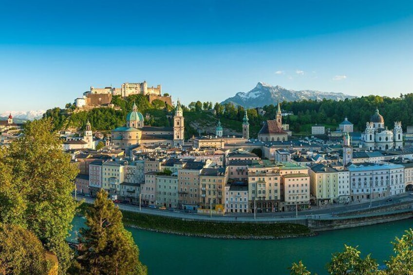 Un paisaje urbano con edificios históricos, un río y un castillo en una colina. 5