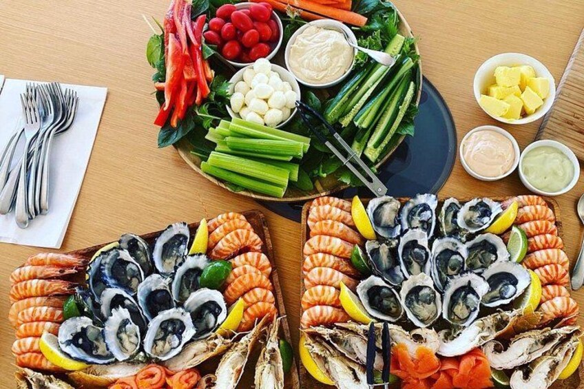A seafood platter with shrimp, oysters, and vegetables. 2