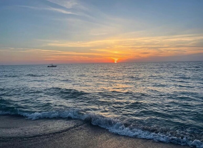 Ein Sonnenuntergang über dem Meer mit Wellen am Ufer. 4