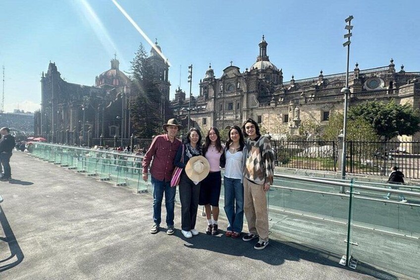 A group of people standing on a bridge with a historic building in the background. 2