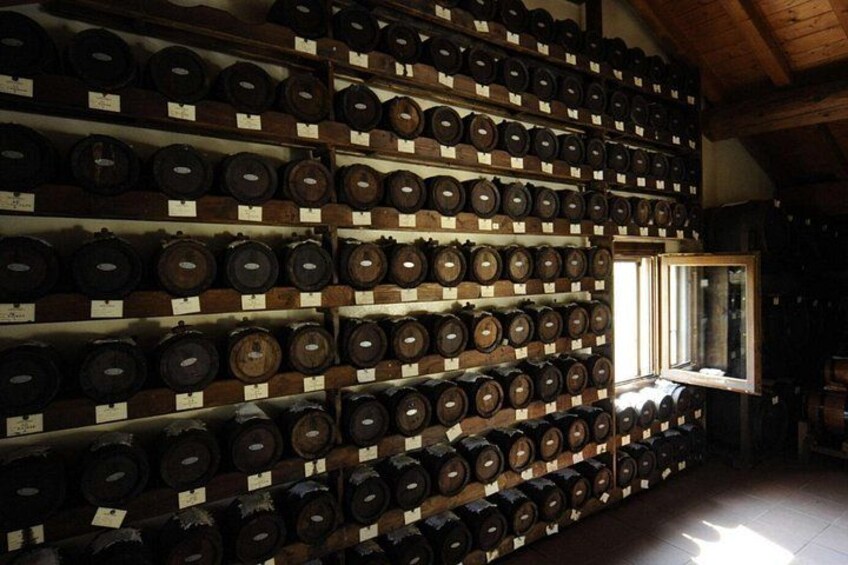 A wine cellar with rows of wooden barrels. 5