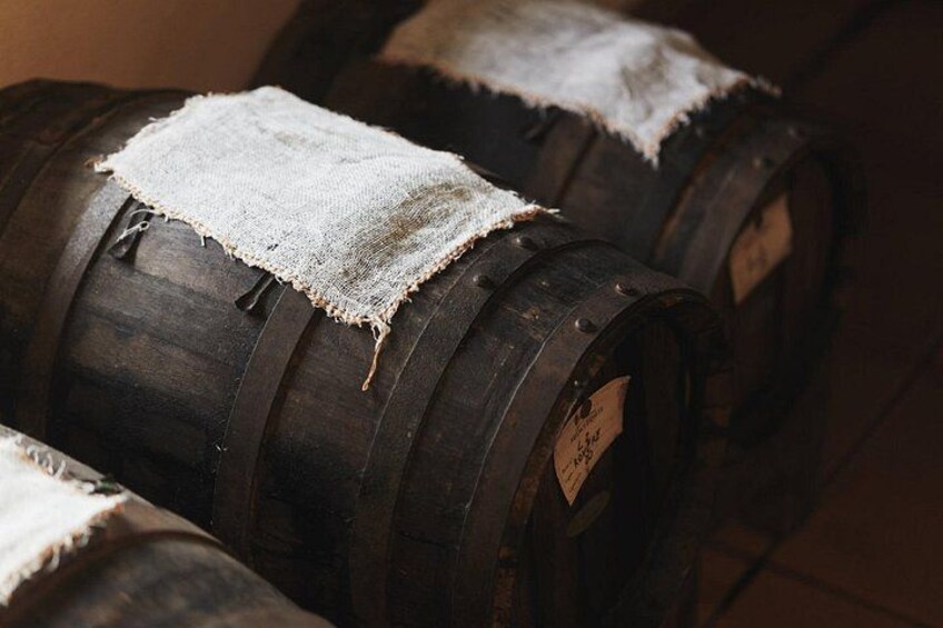 Wooden barrels with labels, some covered with cloth. 1