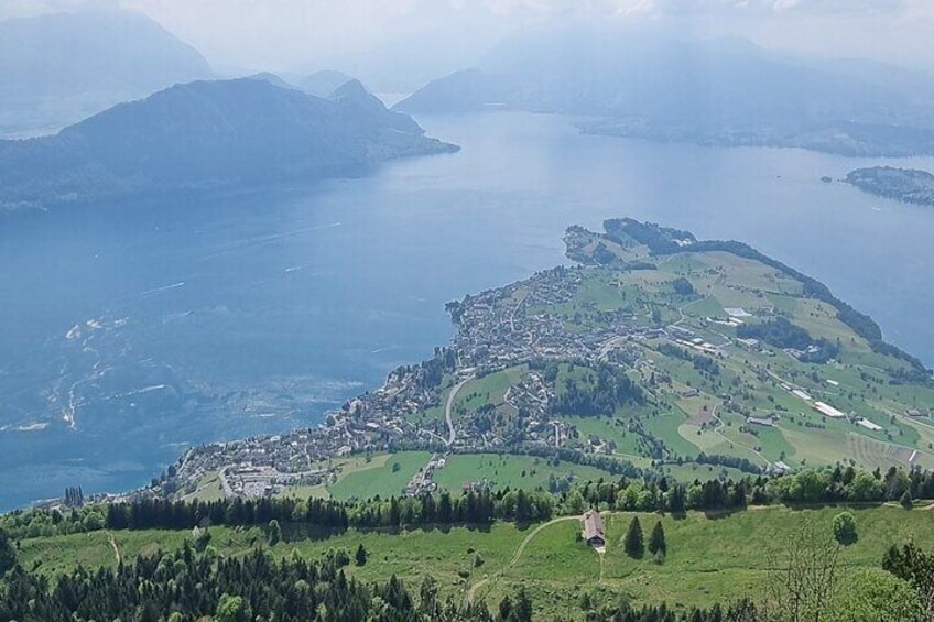 A coastal town with a harbor, surrounded by green hills and mountains. 5