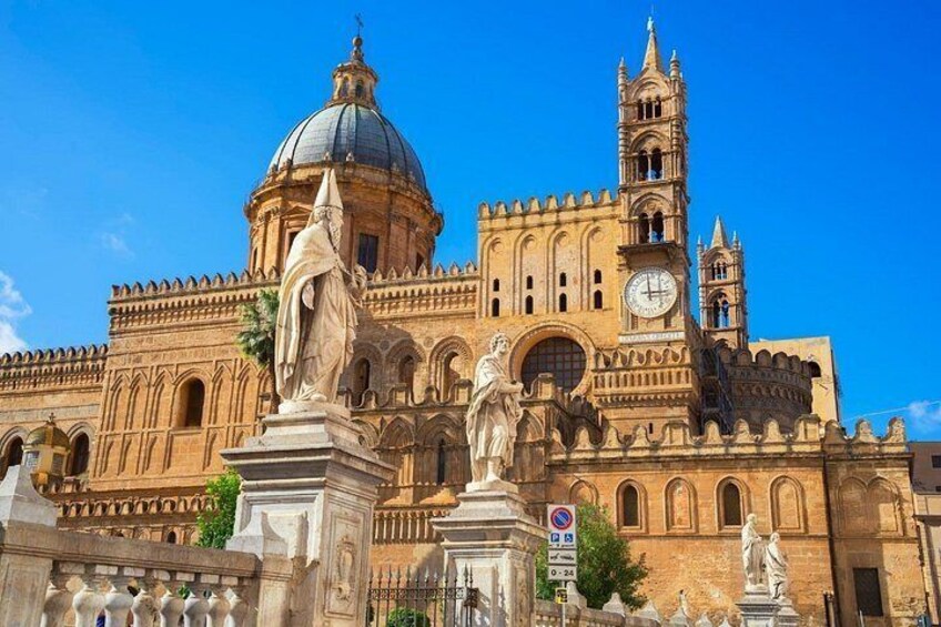 A historic cathedral with a large dome, bell tower, and statues. 3