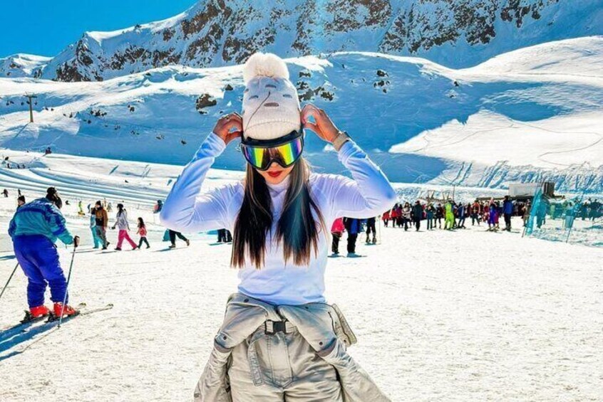 Una persona esquiando en una pendiente nevada, con gente al fondo. 5