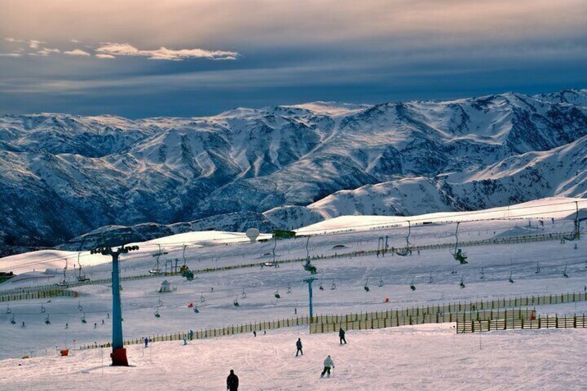 Pista de esquí cubierta de nieve con remontes y montañas al fondo. 4