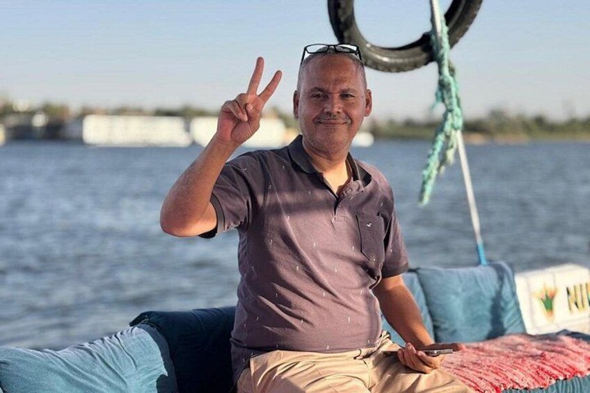 A person on a boat with a water body in the background. 1