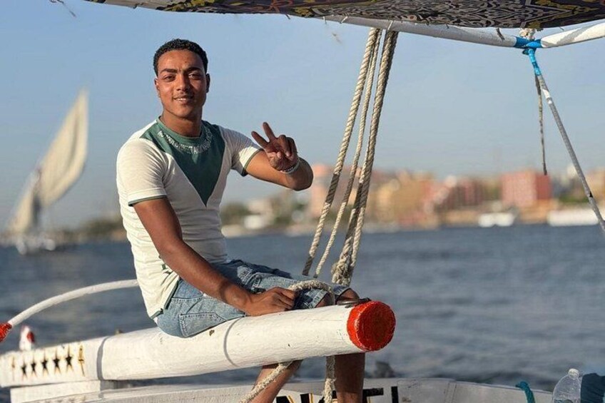 A person sitting on a boat with a cityscape in the background. 3
