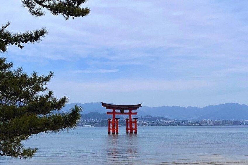 A red torii gate in water with mountains in the background. 2