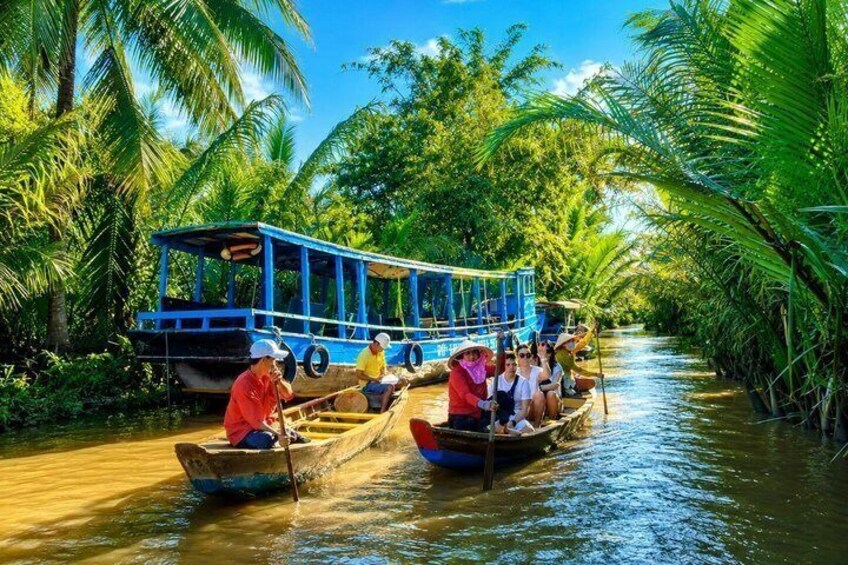 A river with boats, palm trees, and a clear sky. 2