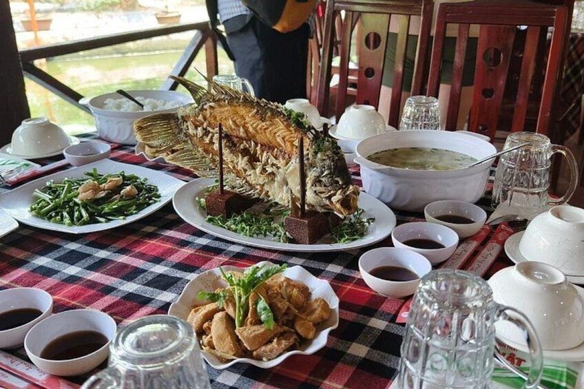 A table with a whole roasted fish, various side dishes, and multiple bowls of sauces. 5