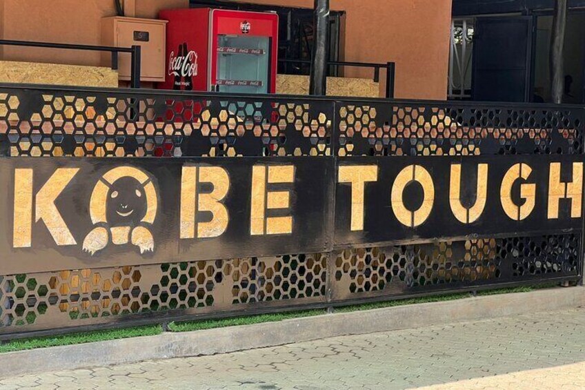 A sign with the text "KOBE TOUGH" and a graphic of a bear. 1