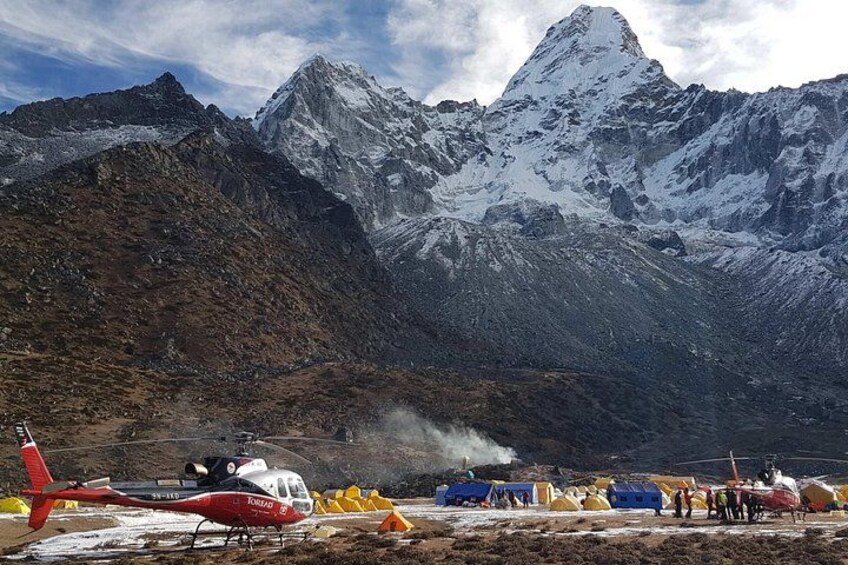 Un hélicoptère, des tentes et un paysage montagneux. 1