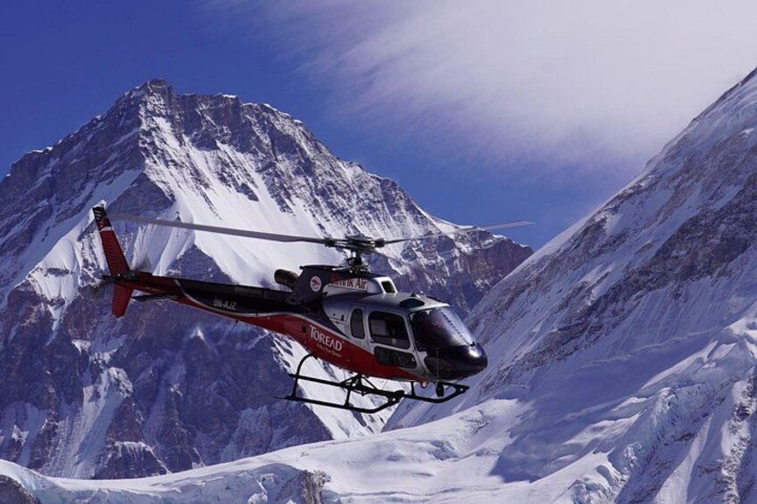 Un hélicoptère survole une chaîne de montagnes enneigées. 5