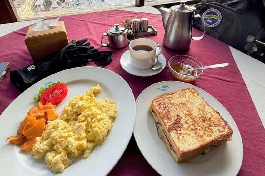 Une table mise pour le petit-déjeuner, avec des œufs brouillés, des toasts et une tasse de café. 2