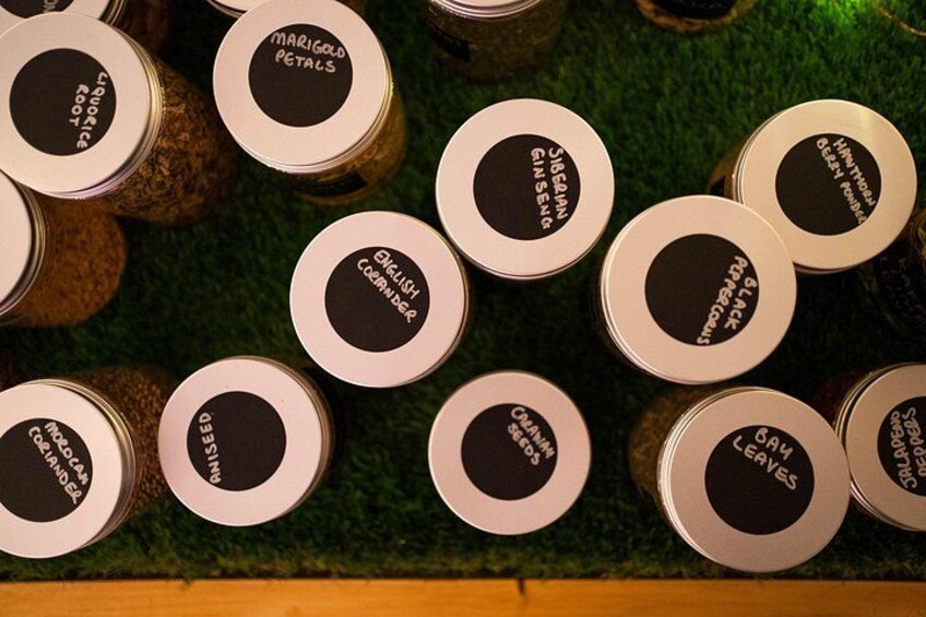 A collection of jars with labels on a green surface. 2