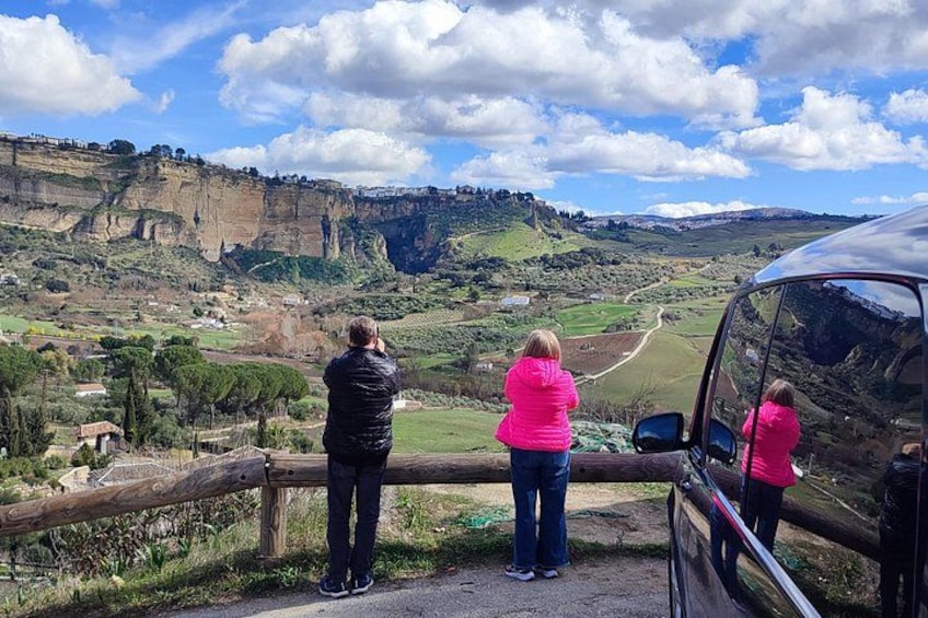 A scenic landscape with cliffs, a winding road, and a parked vehicle. 4
