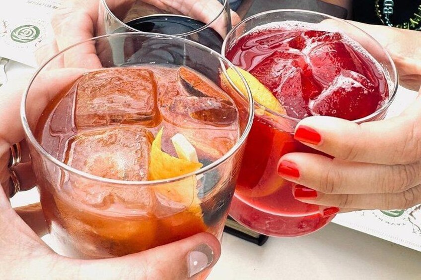 Due persone che sorseggiano bicchieri di bevande ghiacciate con cubetti di ghiaccio e fettine di frutta. 4