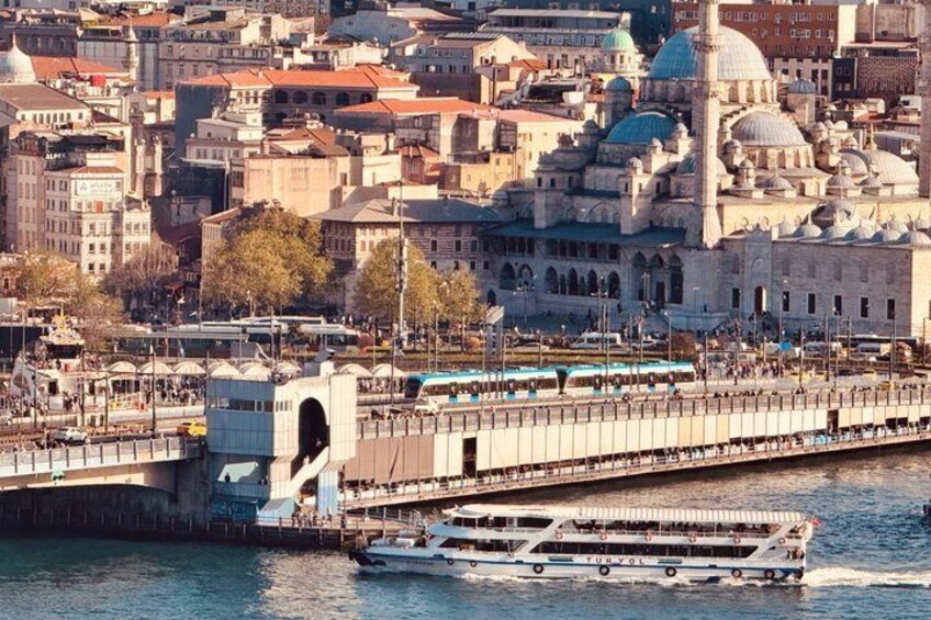 A cityscape with a prominent mosque, a bridge, and a ferry in the water. 3