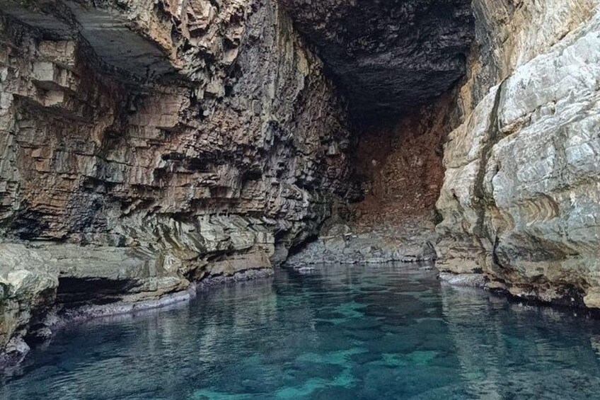 En naturlig grotta med klart vatten och klippiga väggar. 3