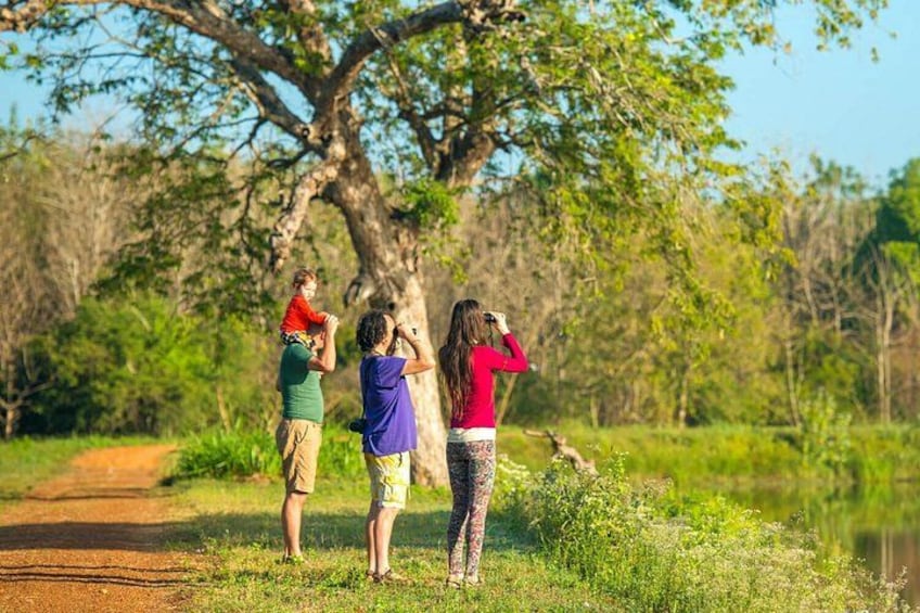Three people standing on a path, one holding a child, and another taking a photo. 4