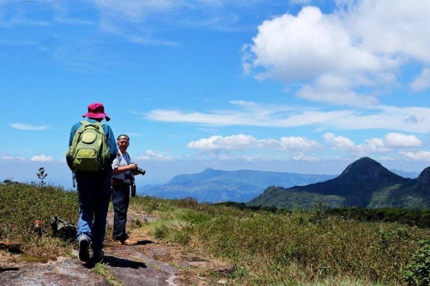 Two hikers on a trail with a mountainous landscape in the background. 2