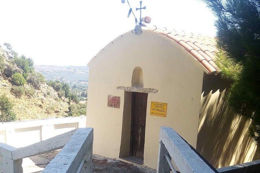 Un piccolo edificio con una croce sulla sommità, una porta e un cartello. 4