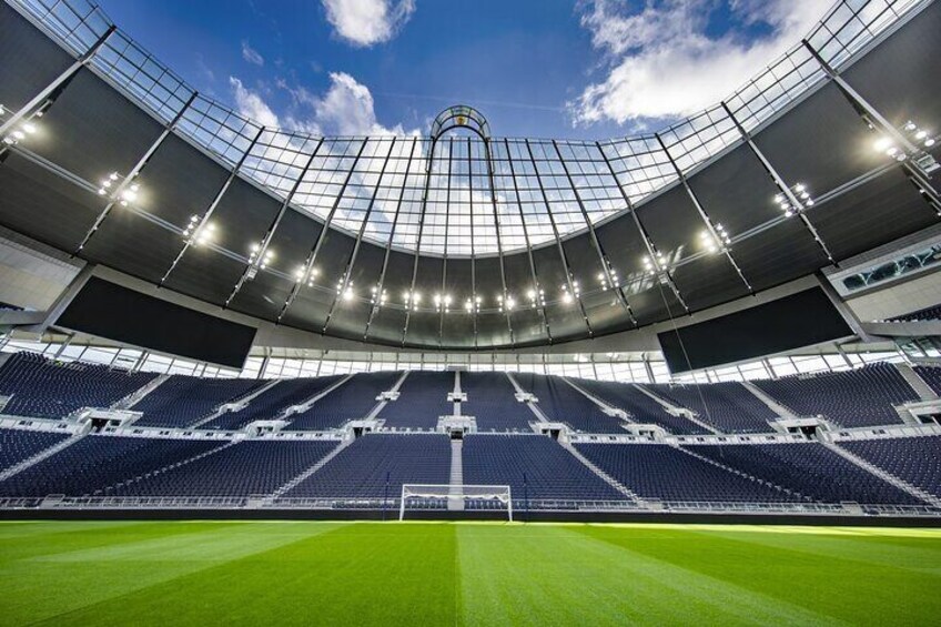 A large, empty stadium with a curved roof and multiple tiers of seating. 4