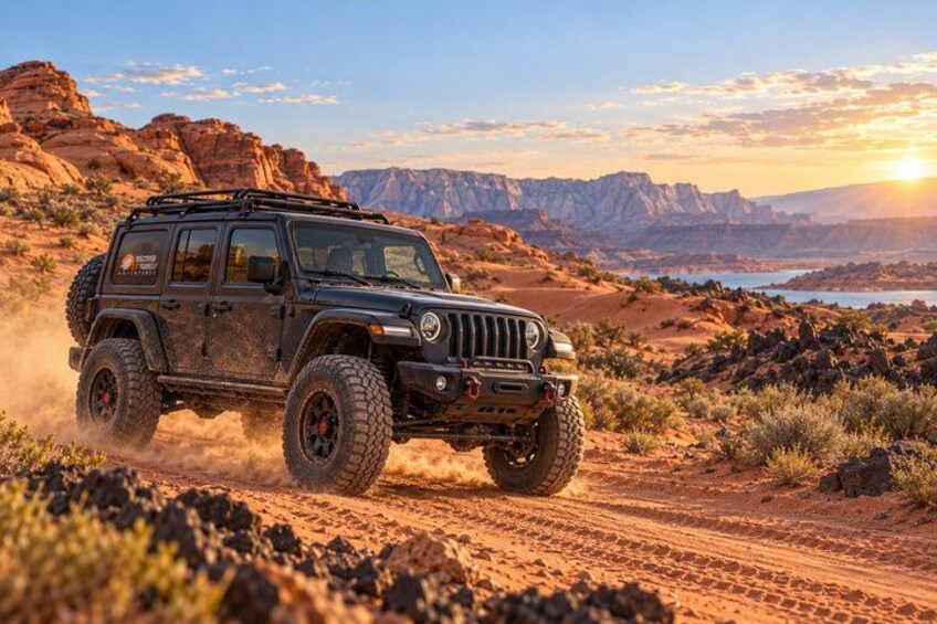 A black off-road vehicle driving on a dirt road in a desert landscape with mountains in the background. 1