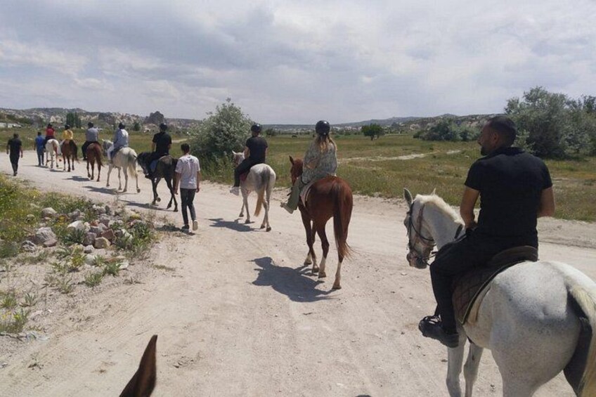 Un grupo de personas montando a caballo por un camino rural. 4