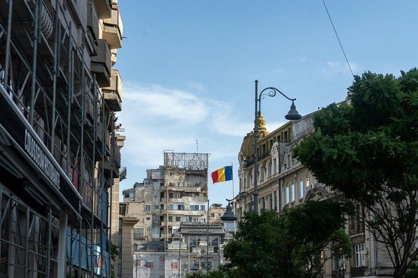 En stadsbild med en flagga, byggnader och en gatlykta. 4