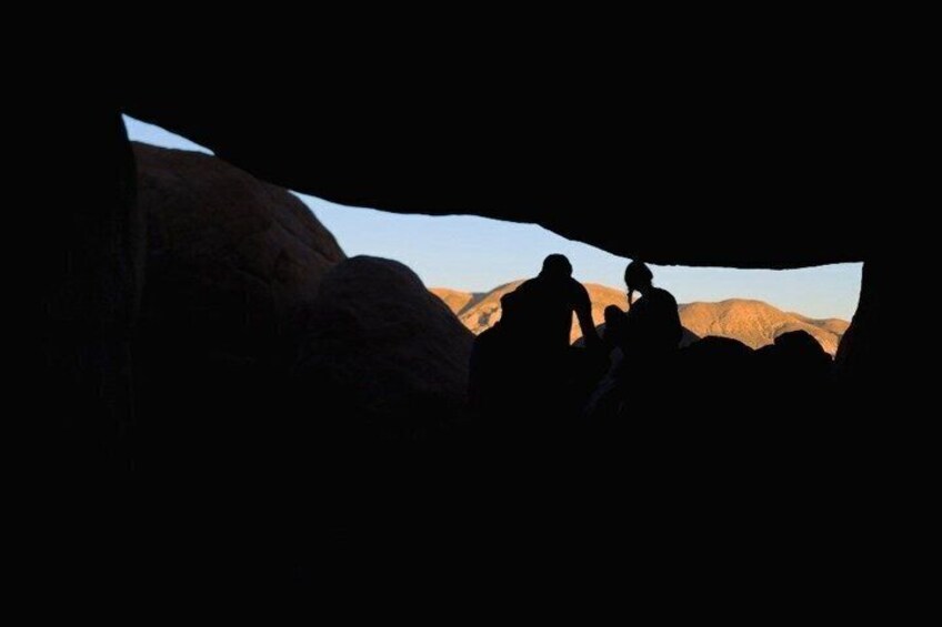 A cave entrance with a silhouette of people inside. 2