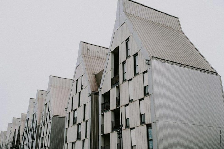 A row of modern buildings with angular roofs and a uniform facade. 2