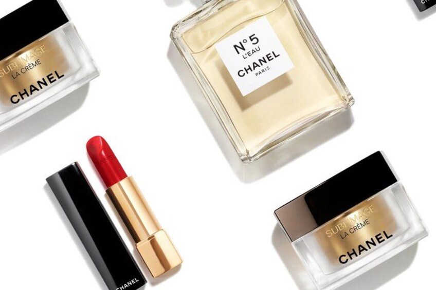 Un rouge à lèvres rouge, un flacon de parfum et une poudre compacte au motif noir et or. 5