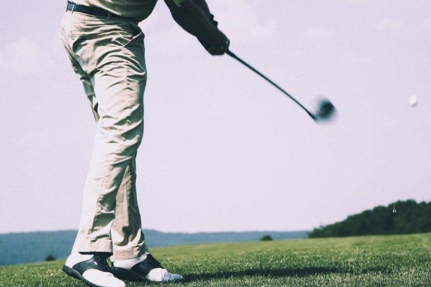 Una persona con pantalón caqui y una chaqueta oscura jugando al golf. 1